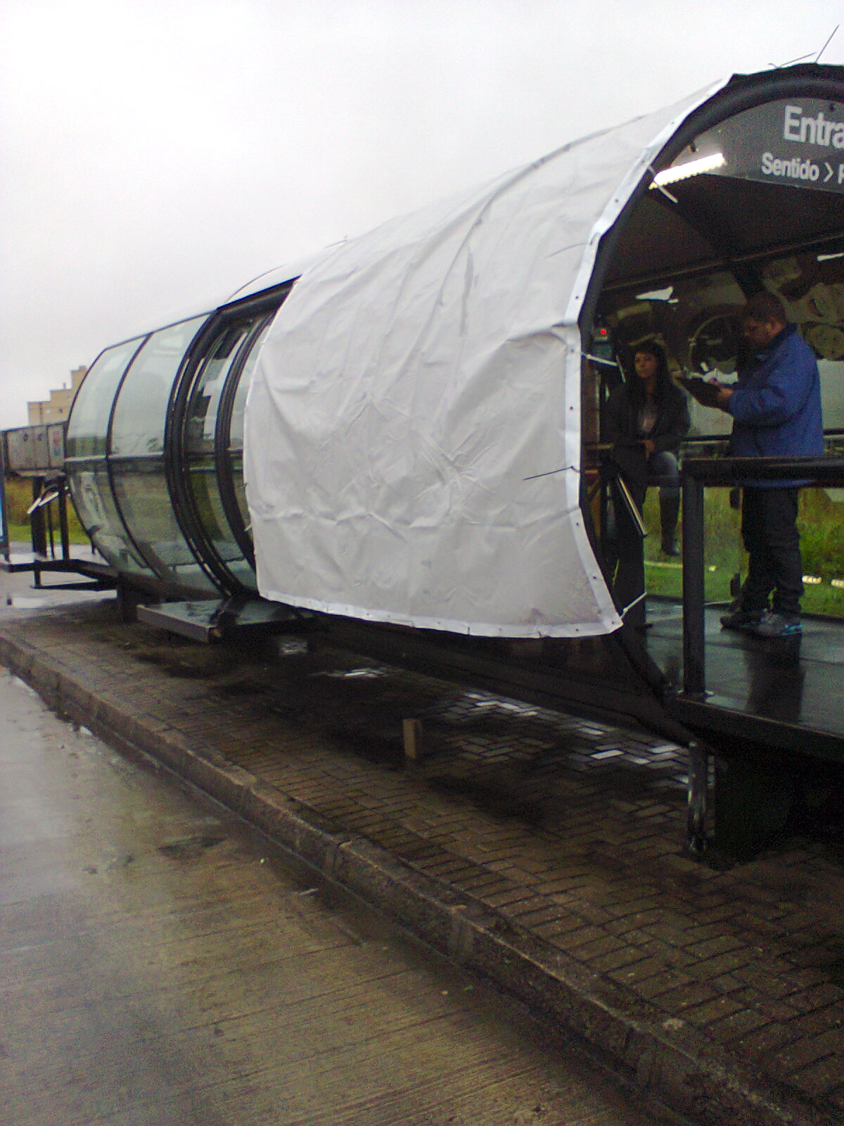 Estação-tubo é coberta com lona para proteger cobradores da chuva