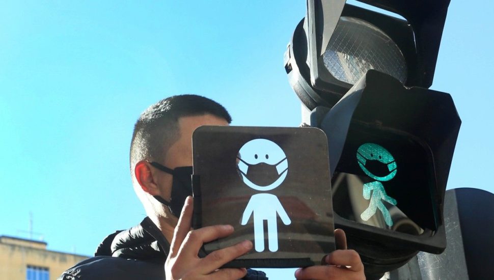 Semáforos de pedestres ganham máscaras pra reforçar a necessidade de proteção contra a covid-19